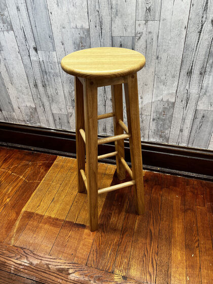 Oak bar stool photographed from a low dramatic angle