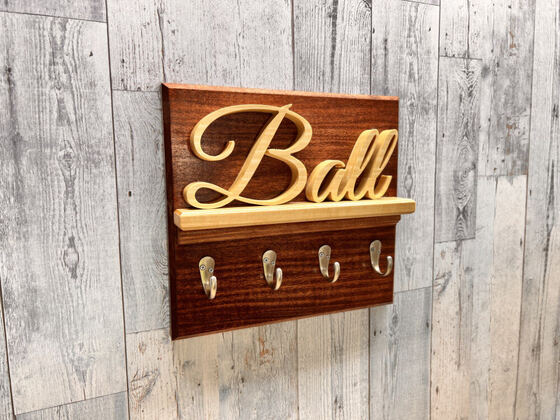 Scroll-cut family name key rack with brass hooks