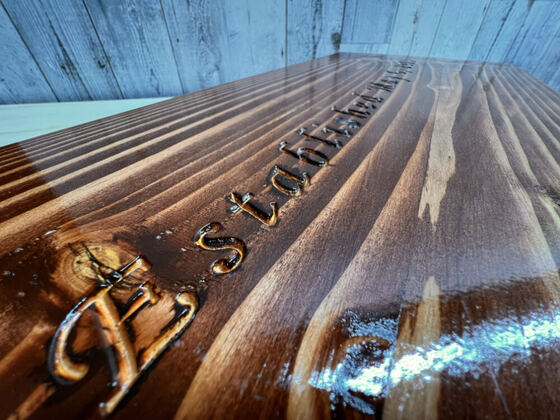 Macro of hand-carved script lettering in wood