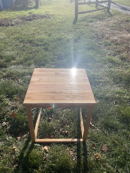 Finished oak end table photographed outdoors