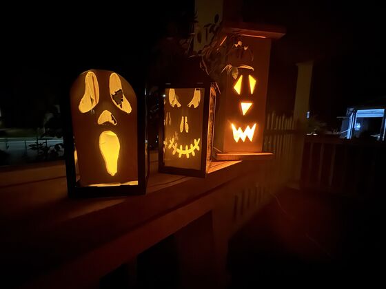 A set of handmade Halloween lanterns lighting up a porch rail